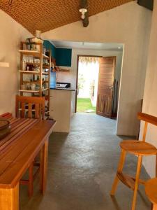 卡诺格布拉达Casa Flora Canoa Quebrada的厨房配有木桌、椅子和门