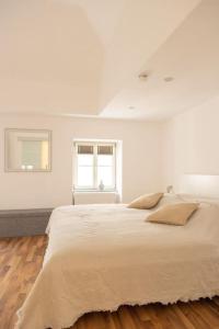 帕绍Apartment Altstadt Passau的白色卧室设有一张大床和两个窗户