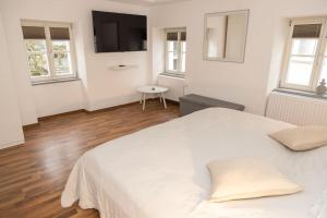 帕绍Apartment Altstadt Passau的一间白色卧室,配有一张大床和一台电视