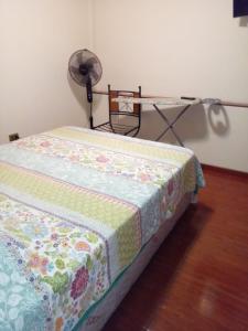 安托法加斯塔Baquedano的一张带被子的床铺,配有风扇