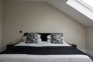 HenwickLuxury Worcester Townhouse - Free Parking的一间卧室配有一张大床,提供黑白枕头