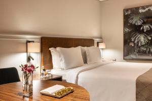 圣保罗圣保罗波尔图湾酒店的酒店客房设有一张大床和一张桌子。