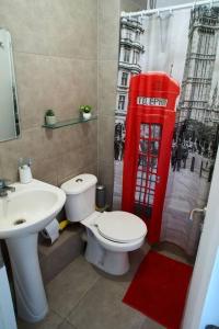 阿里卡Departamento amoblado en arriendo的一间带卫生间、水槽和红色电话亭的浴室