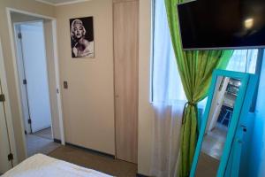阿里卡Departamento amoblado en arriendo的一间配有电视的房间和一个带窗帘的窗户