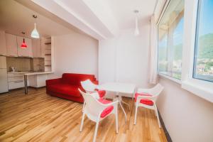 蒂瓦特Apartment DV Magnolia的客厅配有桌椅和红色沙发