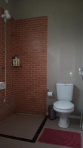 穆隆古Terraço Guaramiranga的浴室设有白色卫生间和砖墙