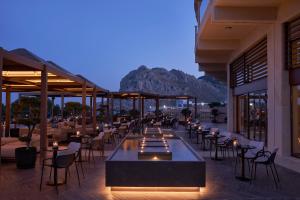 科林比亚Atlantica Imperial Resort - Adults Only的餐厅配有桌椅,位于山脚下