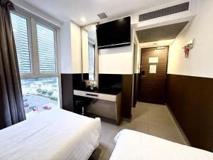 新加坡The Snooze Hotel at Bugis的酒店客房设有两张床和电视。