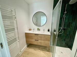 塞尼奥斯Villa Patio à 800 m de la plage的浴室配有盥洗盆和带镜子的淋浴