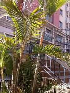 内罗毕Best suites Mvuli的一座带楼梯的建筑前的棕榈树