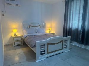 利伯维尔Villa bord de mer louis的卧室配有白色的床和2个床头柜