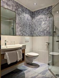 劳里斯布劳酒店的浴室配有卫生间、盥洗盆和淋浴。