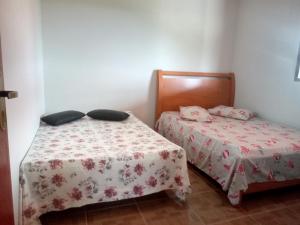 圣托梅-达斯莱特拉斯Chales Horizonte das Pedras的小型客房配有两张床。