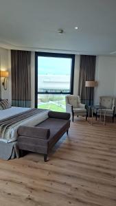 桑坦德港湾酒店的一间卧室设有一张大床和一个大窗户