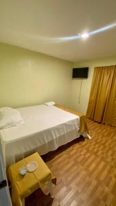圣塔芭芭拉-山美纳Paraíso de Rojas hotel的酒店客房配有一张床铺和一张桌子。