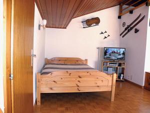 韦尔科兰La Montagnette, VERCORIN的一间卧室配有木床和电视
