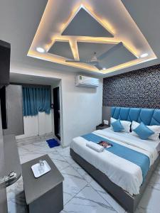 艾哈迈达巴德HOTEL THE PACIFIC的一间卧室配有一张带蓝色枕头的大床