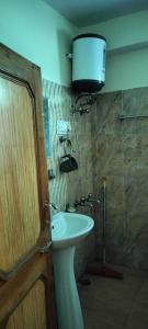 哈里瓦Hotel Gopi Dham Ashram Haridwar Near Vrindavan的浴室配有水槽和墙上的灯。