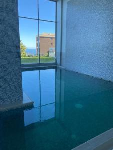康康Departamentos Mednav Montemar & Spa的水中反射的建筑物中的游泳池