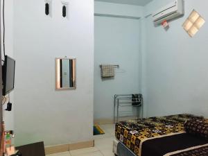 普拉亚Wisma Dhana Syariah的一间卧室配有一张床和镜子