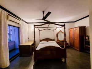 科伦坡VILLA COLOMBO7 5BR HOLIDAY HOME UP to 10 Guests的一间卧室配有天蓬床和吊扇