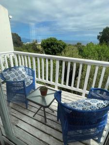 赫曼努斯Joy@Grotto Beach, Hermanus的甲板上配有2把蓝色的椅子和一张桌子