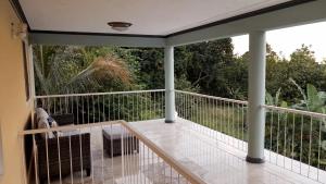 金斯敦Bougainvillea Palms的屏蔽在门廊上,享有树林美景