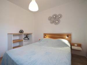 蒙塔尼亚克GITE DE LA TRUFFIERE "Les Chênes"的一间卧室配有一张带灯具的白色床