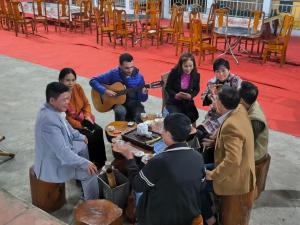 河江森翠民宿的一群人坐在桌子旁播放音乐