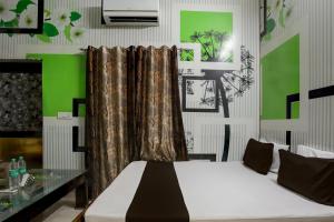 JīndOYO Home 82227 Malik Hotel的一间卧室设有一张床和绿色的墙壁