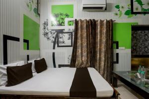 JīndOYO Home 82227 Malik Hotel的一间卧室配有一张绿色和白色的床