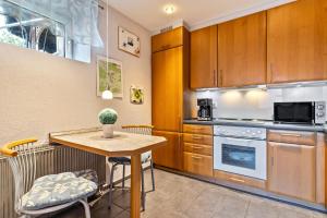 巴登-巴登豪斯蒙泰罗萨公寓的厨房配有木制橱柜和桌椅