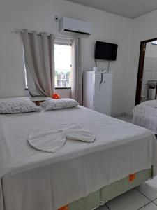 博阿维斯塔Hotel Monte Arau的一张白色的床,上面有两顶帽子