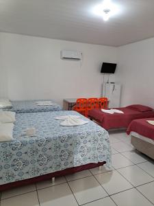 博阿维斯塔Hotel Monte Arau的一间卧室配有两张床和两张橙色椅子