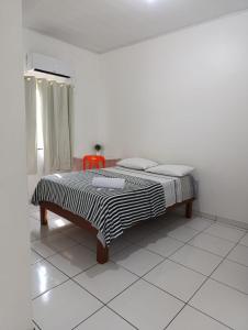 博阿维斯塔Hotel Monte Arau的白色房间的一个床位,红色椅子