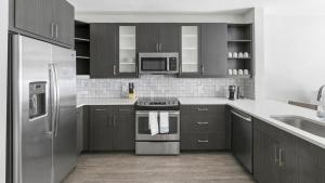 普莱诺Landing - Modern Apartment with Amazing Amenities (ID9504X23)的厨房配有木制橱柜和不锈钢用具