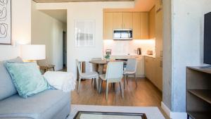 奥克兰Landing Modern Apartment with Amazing Amenities (ID2480X10)的客厅以及带沙发和桌子的厨房。