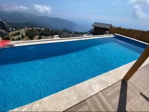 KaraagacALINCA İNFiNİTY VİLLA的一座蓝色的游泳池,后面是群山