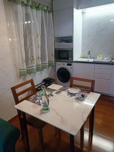 蓬塔德尔加达瓦拉多斯公寓的厨房配有白色的桌椅和水槽