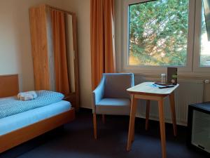 奥茨塞巴德·迪尔哈根Pension Stocker的一间卧室配有一张床、一把椅子和一张桌子