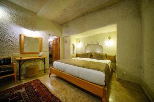 格雷梅萨克斯甘岩洞酒店的一间卧室,卧室内配有一张大床