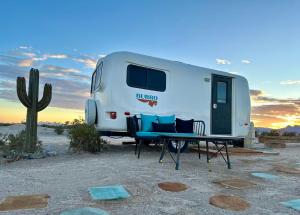 阿马戈萨山谷Tarantula Ranch Campground & Vineyard near Death Valley National Park的沙漠中的一个路人,有桌椅