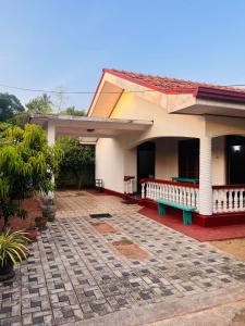尼甘布Ceylon Glory Hostel的前面有长凳的房子