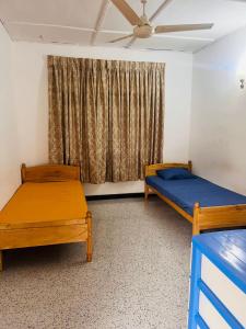 尼甘布Ceylon Glory Hostel的带窗户的客房内的两张床
