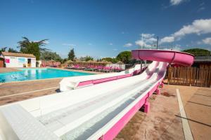 Saint-NazaireCamping Saint-Nazaire的一个带粉色和白色水滑梯的游泳池
