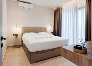 约阿尼纳Ioannina Secret Luxury Villas的一间卧室设有一张大床和一个大窗户