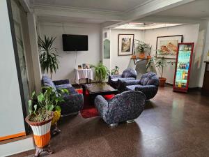 苏克雷Copacabana Hostal的带沙发和椅子的客厅以及电视