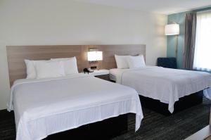 弗利Americas Best Value Inn & Suites-Foley的配有白色床单的酒店客房内的两张床