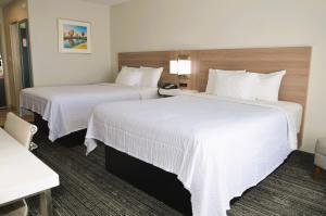 弗利Americas Best Value Inn & Suites-Foley的配有白色床单的酒店客房内的两张床