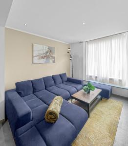 奥邦日Escapade Authentique的客厅配有蓝色的沙发和桌子